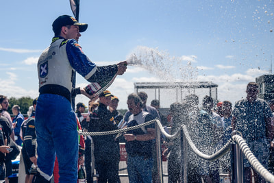 Ecurie Ecosse celebrate race win with champagne